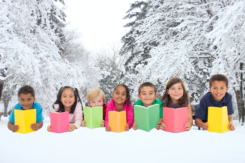 Children holding open colourful book covers, set against snow covered evergreens background