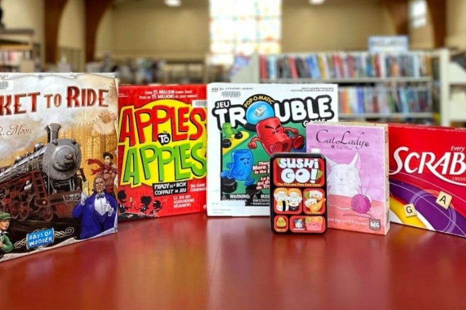 assorted board games including Ticket to Ride, Apples to Apples, Trouble, Sushi Go, and Cat Lady.