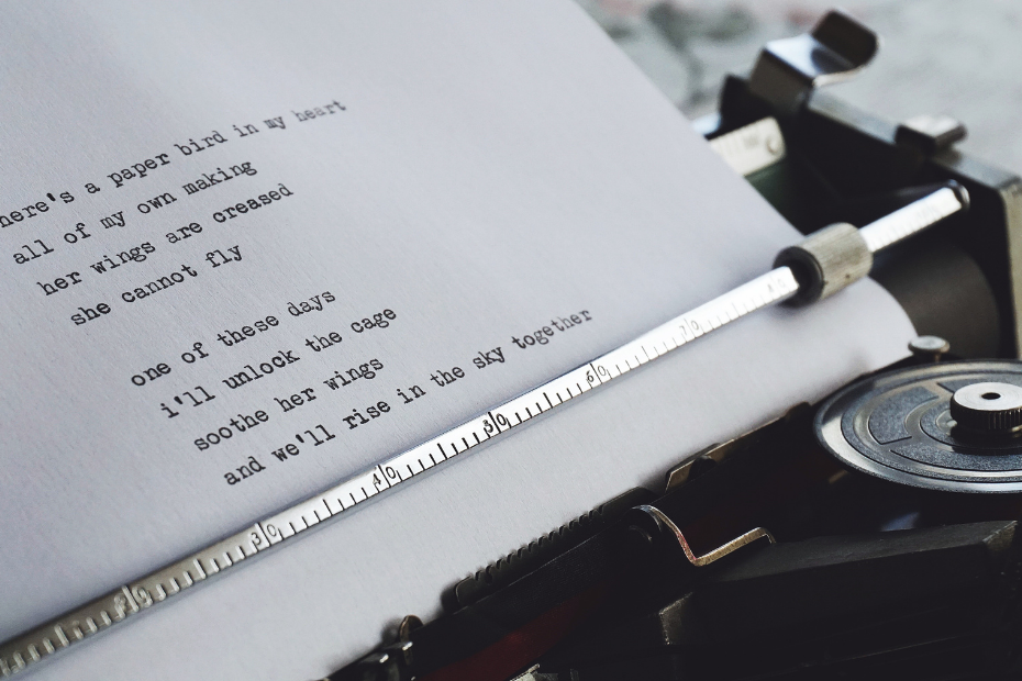 close-up of typewriter with lines of poetry on piece of paper
