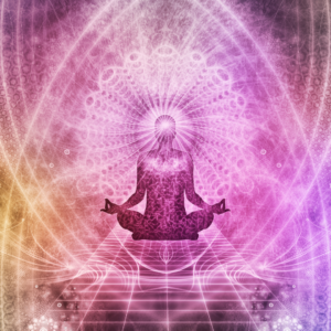 silhouette of person sitting cross-legged and meditating on a mystical pink, yellow, mandala inspired background.