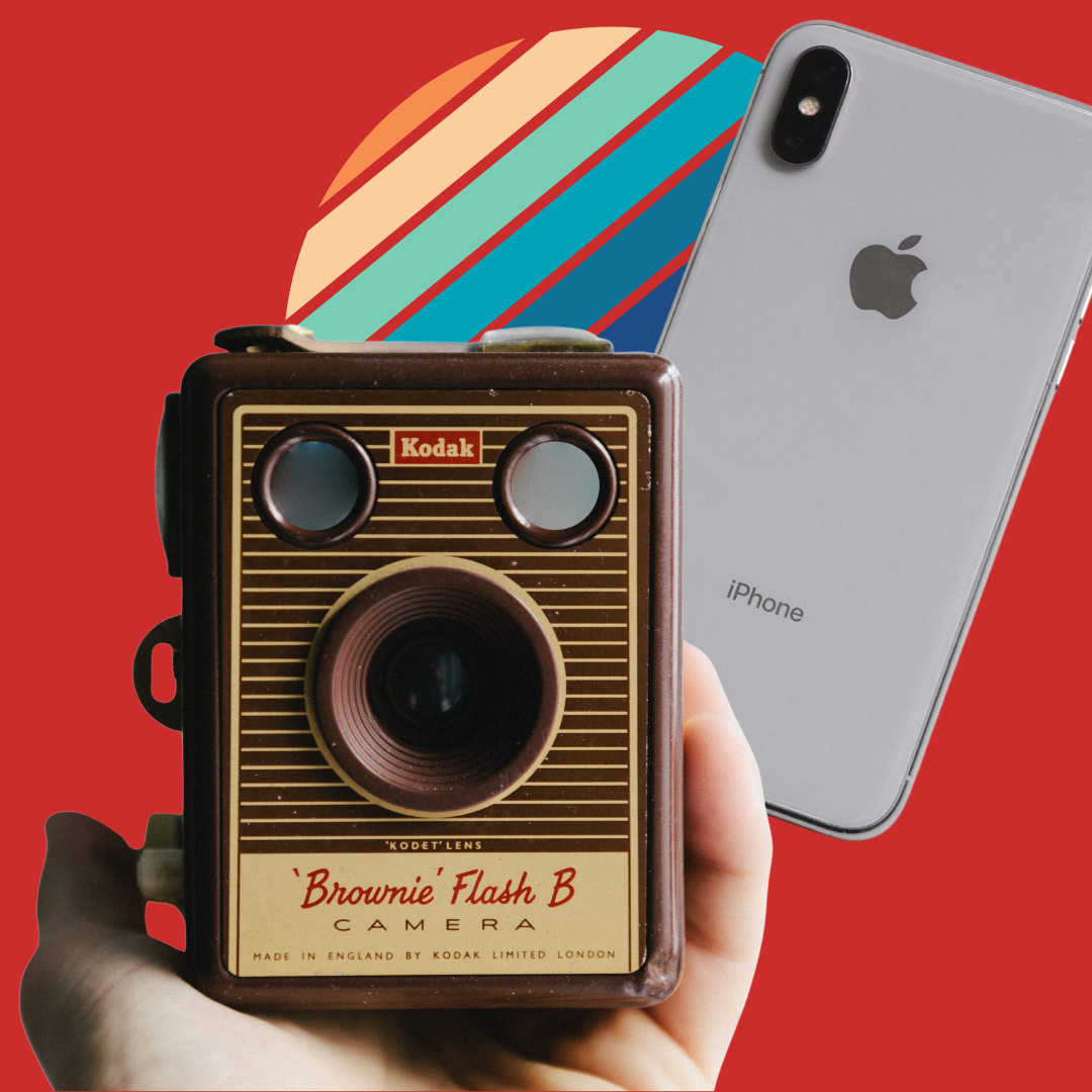Photograph featuring a person holding a Kodak Brownie camera against a red background. An iphone is also pictured for contrast.