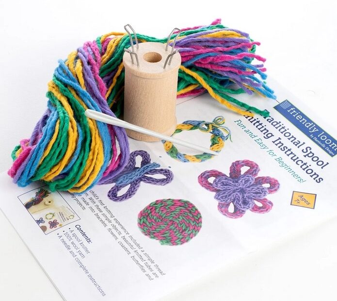 Spool knitting kit contents: yarn, knitting spool, darning needle and instructions.