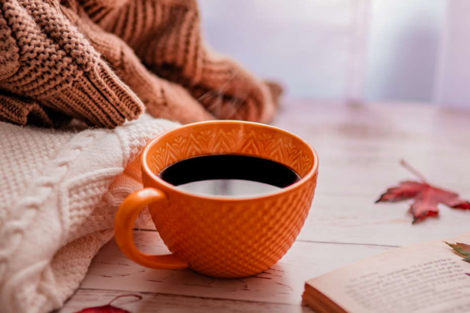 Cozy sweaters, a teacup and a book.